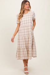 woman wearing a beige plaid tiered midi dress with short sleeves and pockets