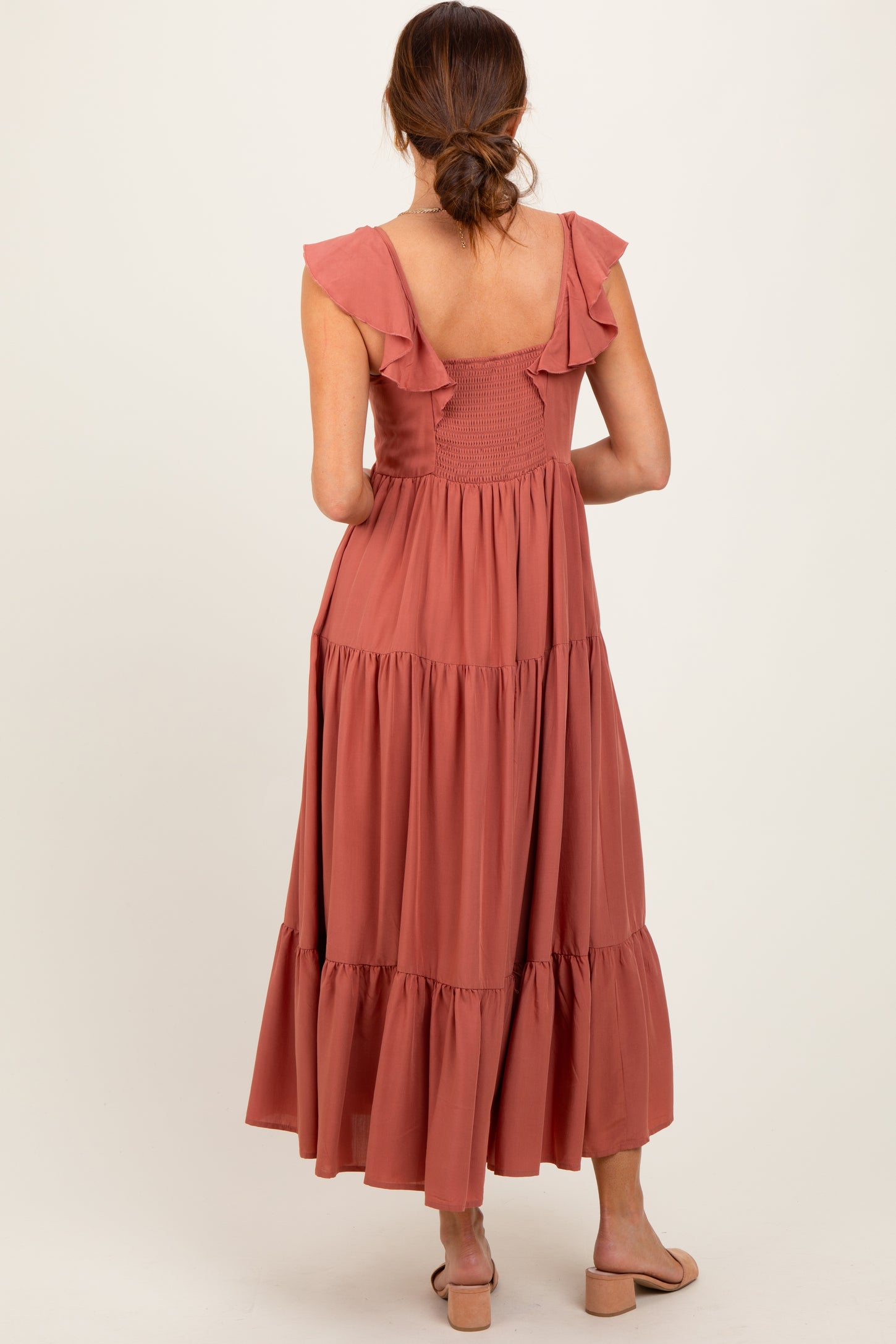 woman wearing a dusty rose maxi dress with ruffle straps and tiered skirt from the back