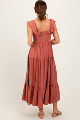 woman wearing a dusty rose maxi dress with ruffle straps and tiered skirt from the back