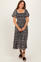 woman wearing a black and white patterned maxi dress with puff sleeves and a smocked bodice