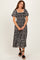 woman wearing a black and white patterned maxi dress with puff sleeves and a smocked bodice