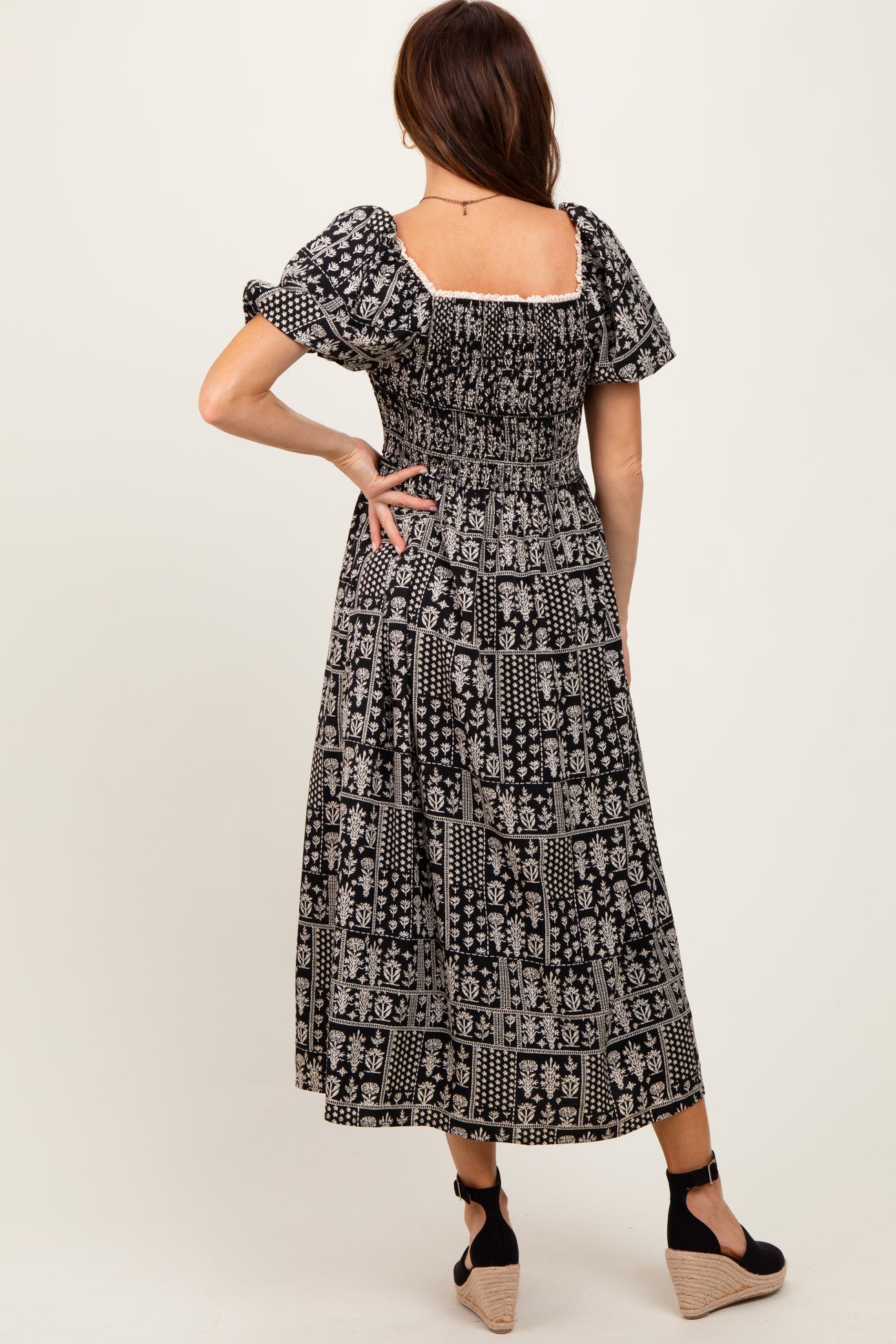 woman wearing a black and white patterned maxi dress with short puff sleeves and a smocked back