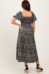 woman wearing a black and white patterned maxi dress with short puff sleeves and a smocked back