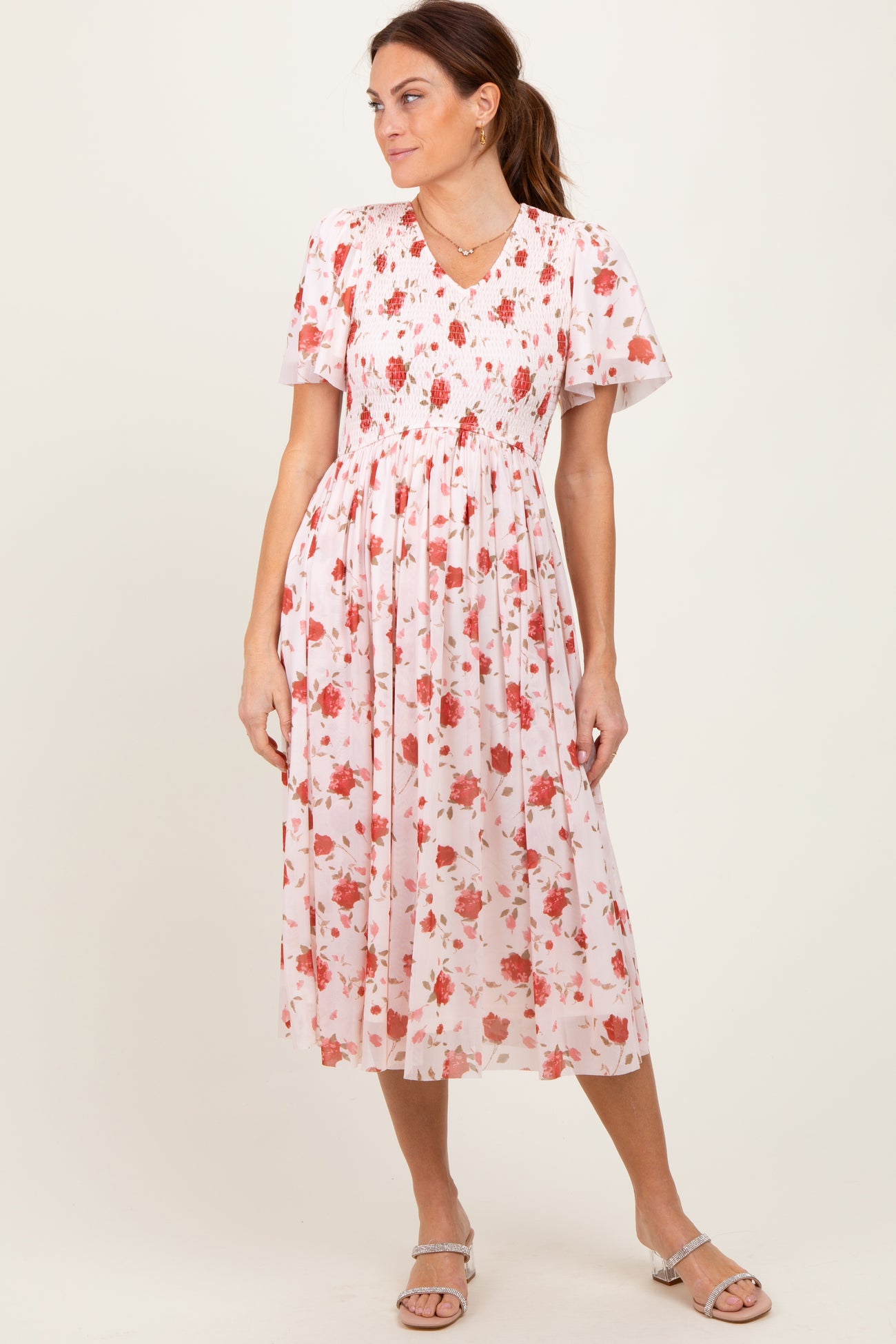 woman wearing a floral midi dress with short sleeves and a smocked bodice