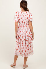 woman wearing a pastel floral midi dress with a smocked bodice and short puff sleeves, shown from the back