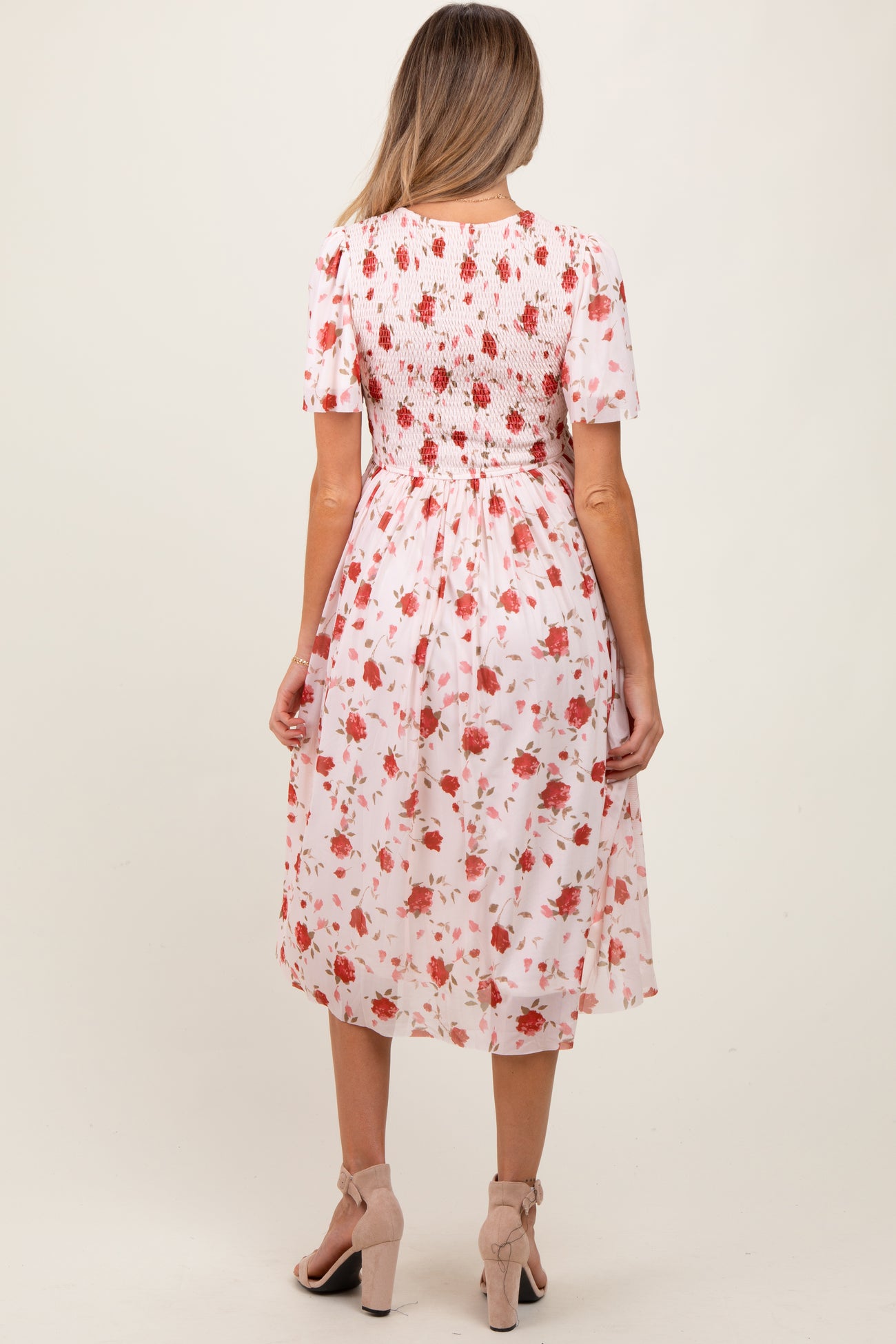 woman wearing a floral maternity dress with short sleeves and a smocked back detail, model shown from the back