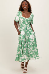 woman wearing a green floral smocked maxi dress with short puff sleeves and pockets