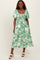 woman wearing a green floral midi dress with puff sleeves and a smocked bodice