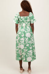 woman wearing a green floral midi dress with short sleeves and a smocked back detail