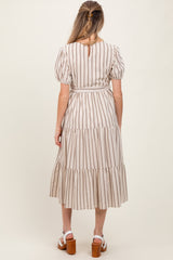 woman wearing a striped maternity maxi dress with puff sleeves and tiered skirt, showing a baby bump from the back