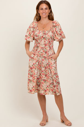 woman wearing a floral midi dress with puff sleeves and pockets, standing on a neutral background