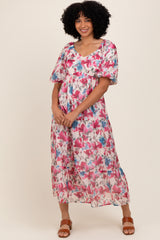 woman wearing a pink and blue floral maxi dress with short sleeves and a relaxed fit
