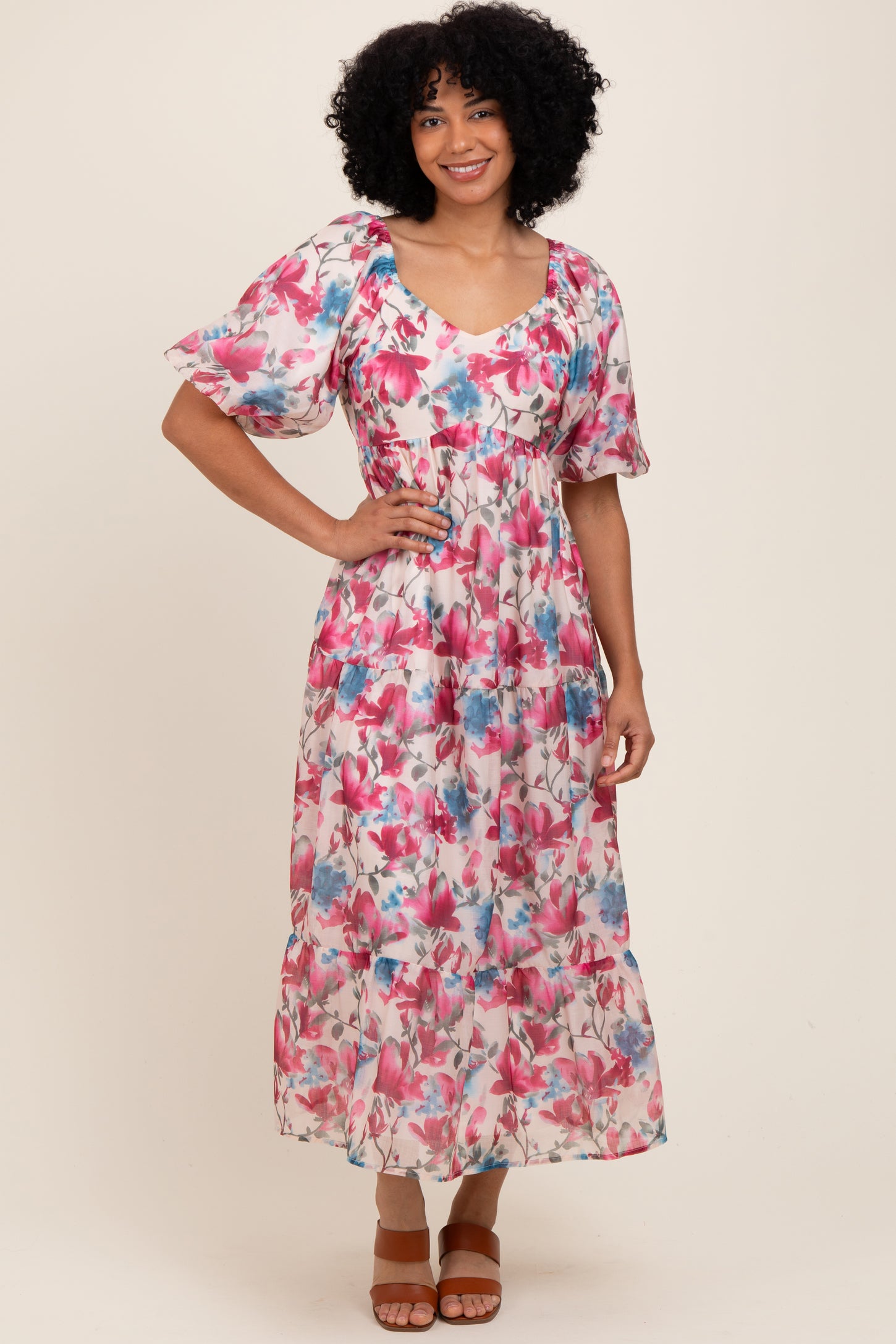 woman wearing a floral maxi dress with pink and blue hues and puffed sleeves