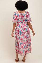 woman wearing a floral maxi dress with pink and blue flowers, featuring puff sleeves and a smocked waist, shown from the back