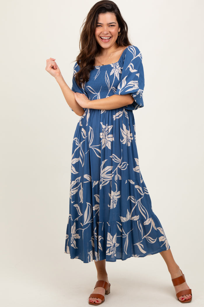 woman wearing a blue floral maxi dress with puff sleeves and a tiered skirt