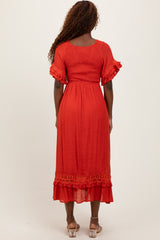 woman wearing a red midi dress with ruffled sleeves and lace trim, viewed from the back