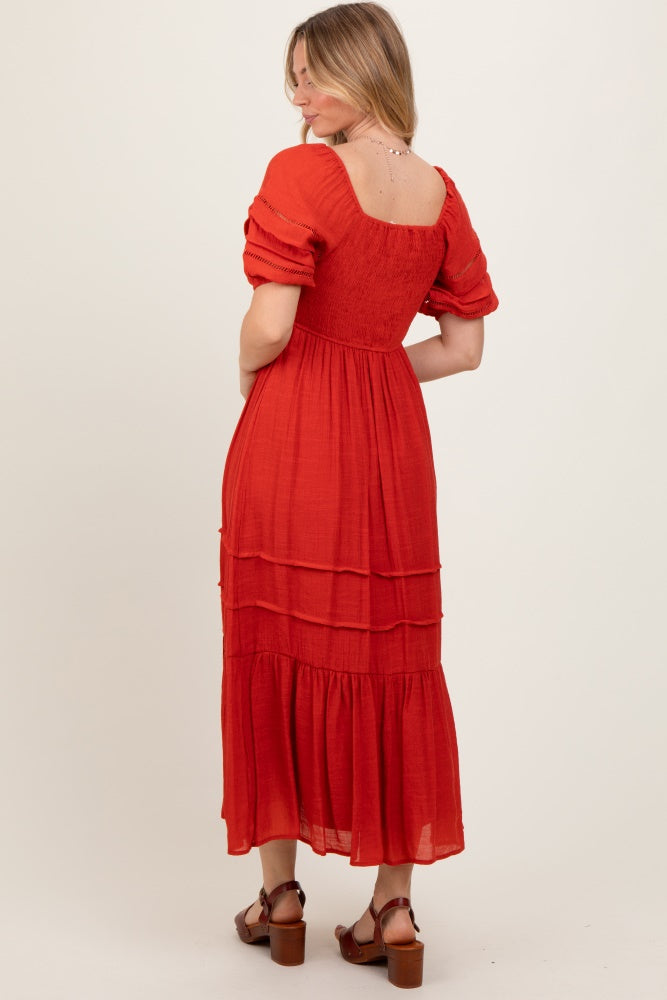 woman wearing a red tiered maxi dress with short puff sleeves and a fitted bodice