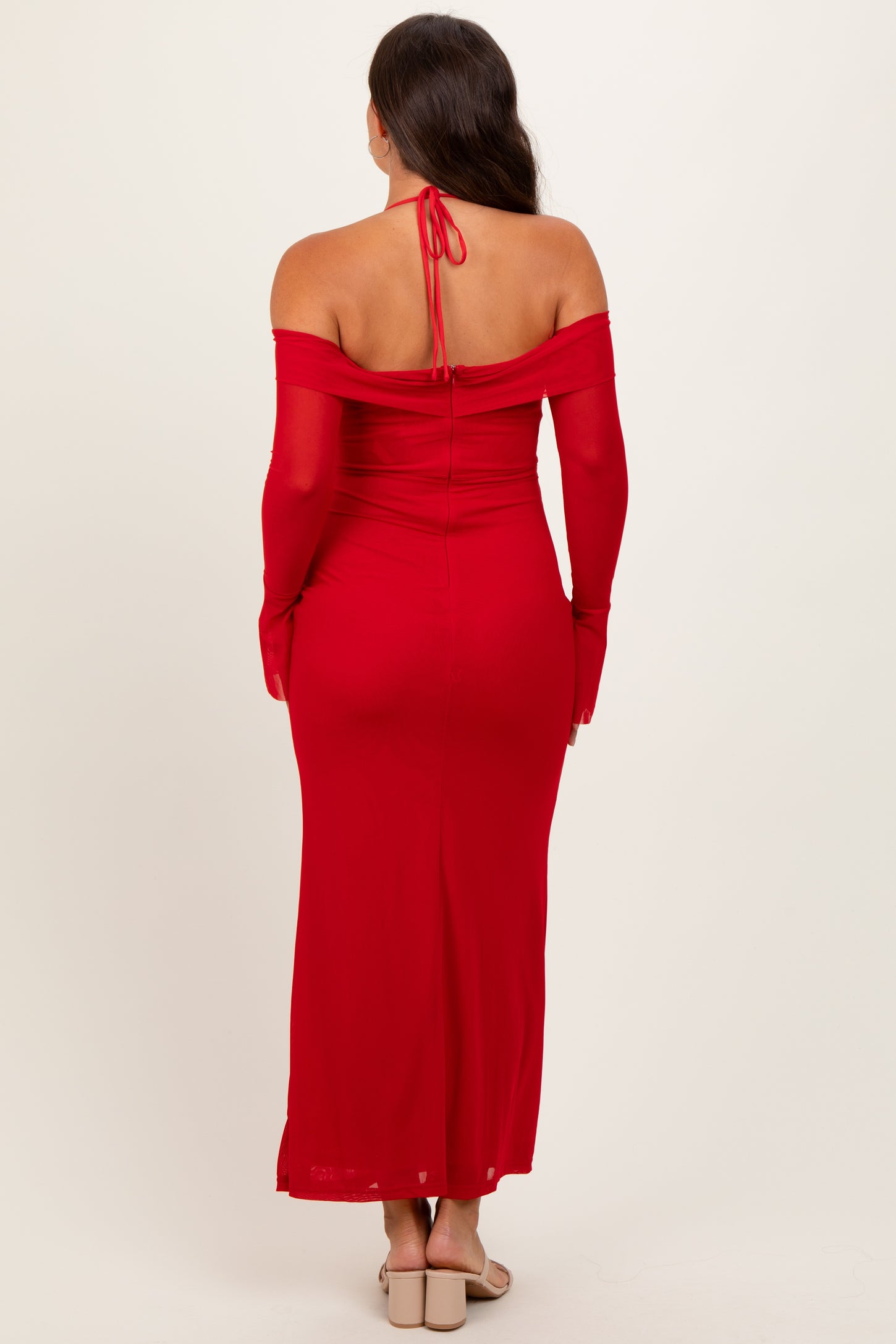 woman wearing a red off-the-shoulder maternity dress with long sleeves, showing a sleek back design
