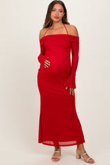 woman wearing a red off-the-shoulder maternity dress with long sleeves and a baby bump visible