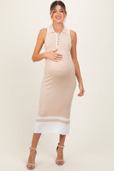 woman wearing a beige ribbed maternity dress with buttons and white stripes, holding her baby bump