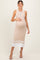 woman wearing a beige ribbed maternity dress with buttons and white stripes, holding her baby bump