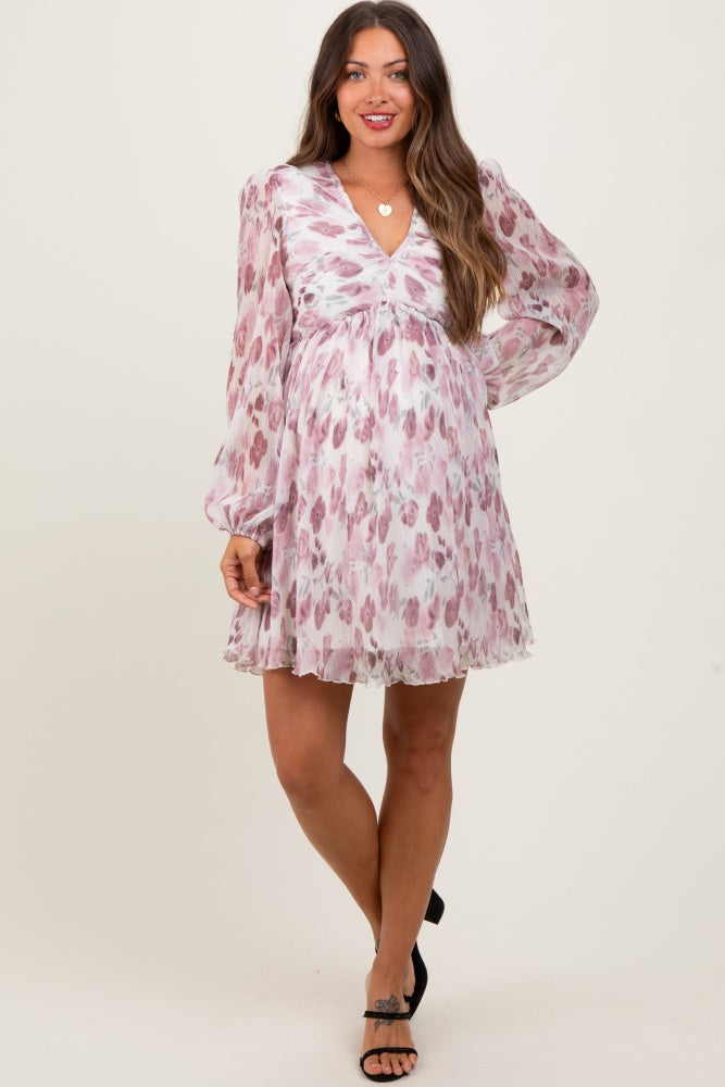 woman wearing a floral print maternity dress with long sleeves and a v-neckline, highlighting her baby bump