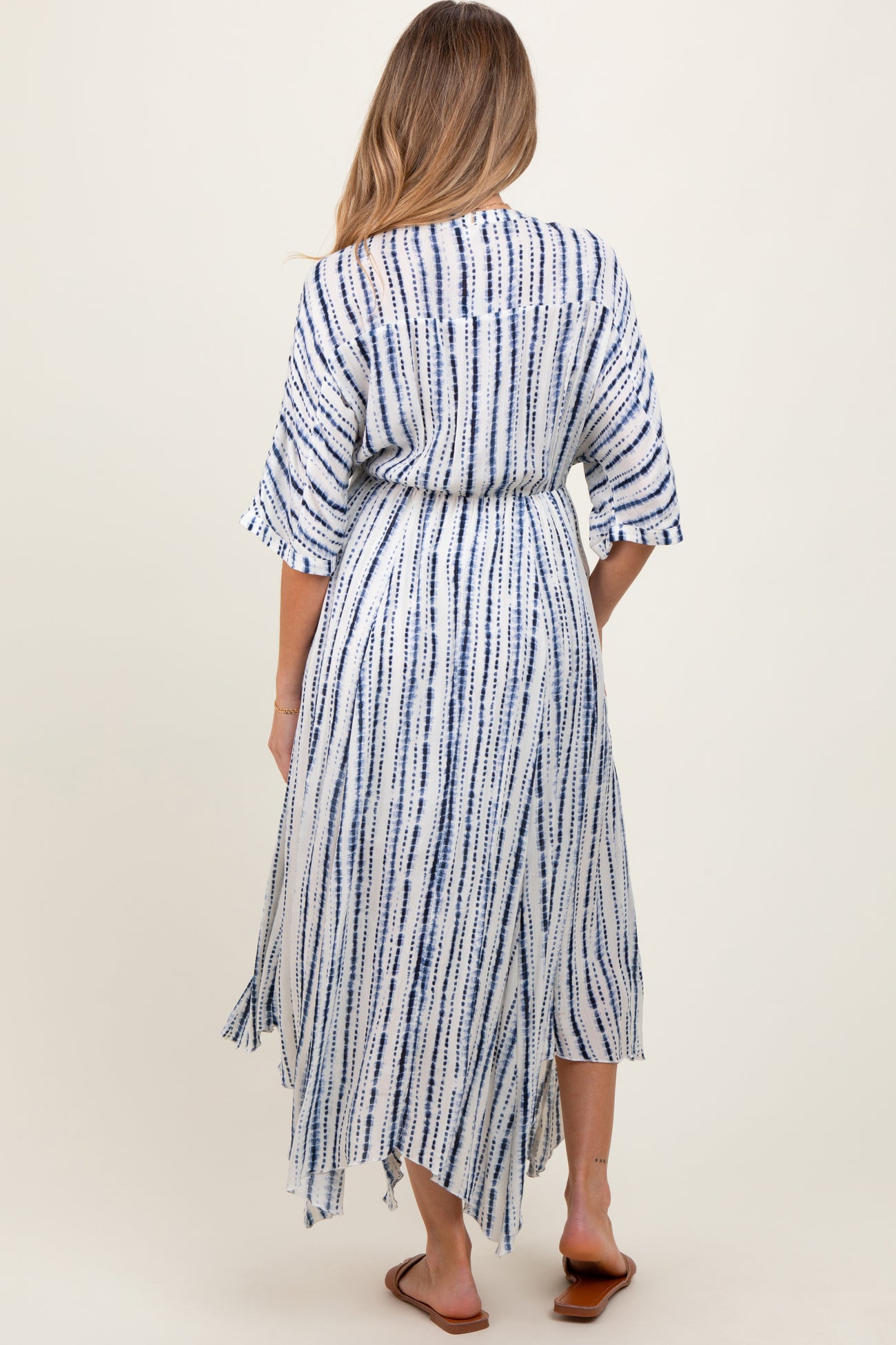 woman wearing a blue and white striped maternity maxi dress with short sleeves and a tie waist from the back