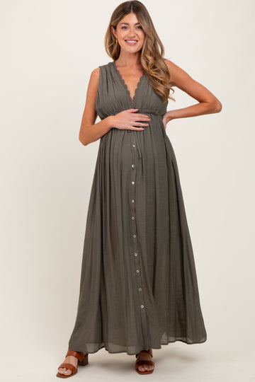 woman wearing a dark green sleeveless maternity maxi dress with a v-neckline and buttons, showing her baby bump