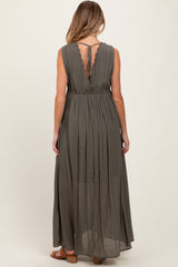 woman wearing a dark olive green sleeveless maternity maxi dress with a lace back detail