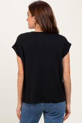 woman wearing a black short sleeve top, seen from the back, paired with blue jeans