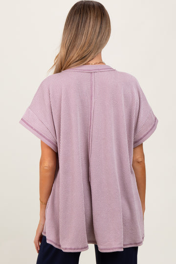 woman wearing a light purple oversized maternity top with short sleeves and a relaxed fit