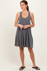 woman wearing a gray ribbed tank dress with a fitted bodice and flared skirt, styled with black slide sandals