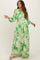 woman wearing a green maternity maxi dress with leaf print and long sleeves, showcasing her baby bump
