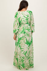 woman wearing a green tropical print maternity maxi dress with long sleeves and an elastic waist