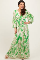 woman wearing a green floral maxi dress with a deep v-neckline and puff sleeves, standing against a neutral background