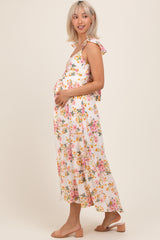 woman wearing a floral maternity maxi dress and holding her baby bump