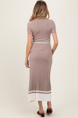 woman wearing a taupe ribbed maternity dress with short sleeves and a white striped hem, showing her baby bump