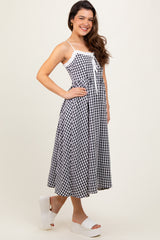 woman wearing a black and white gingham midi dress with spaghetti straps and a tie detail at the front