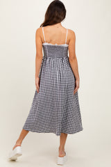 woman wearing a black and white gingham midi dress with a fitted bodice and flowy skirt, viewed from the back