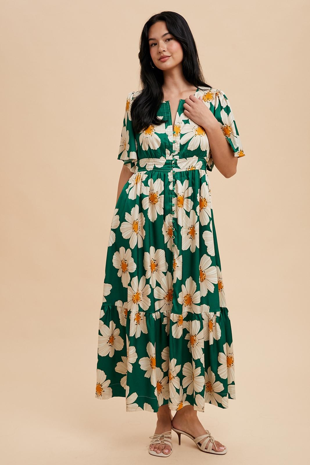 woman wearing a green floral maxi dress with short sleeves and a tiered skirt