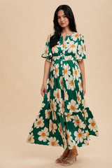 woman wearing a green floral maxi dress with short sleeves and a tiered skirt