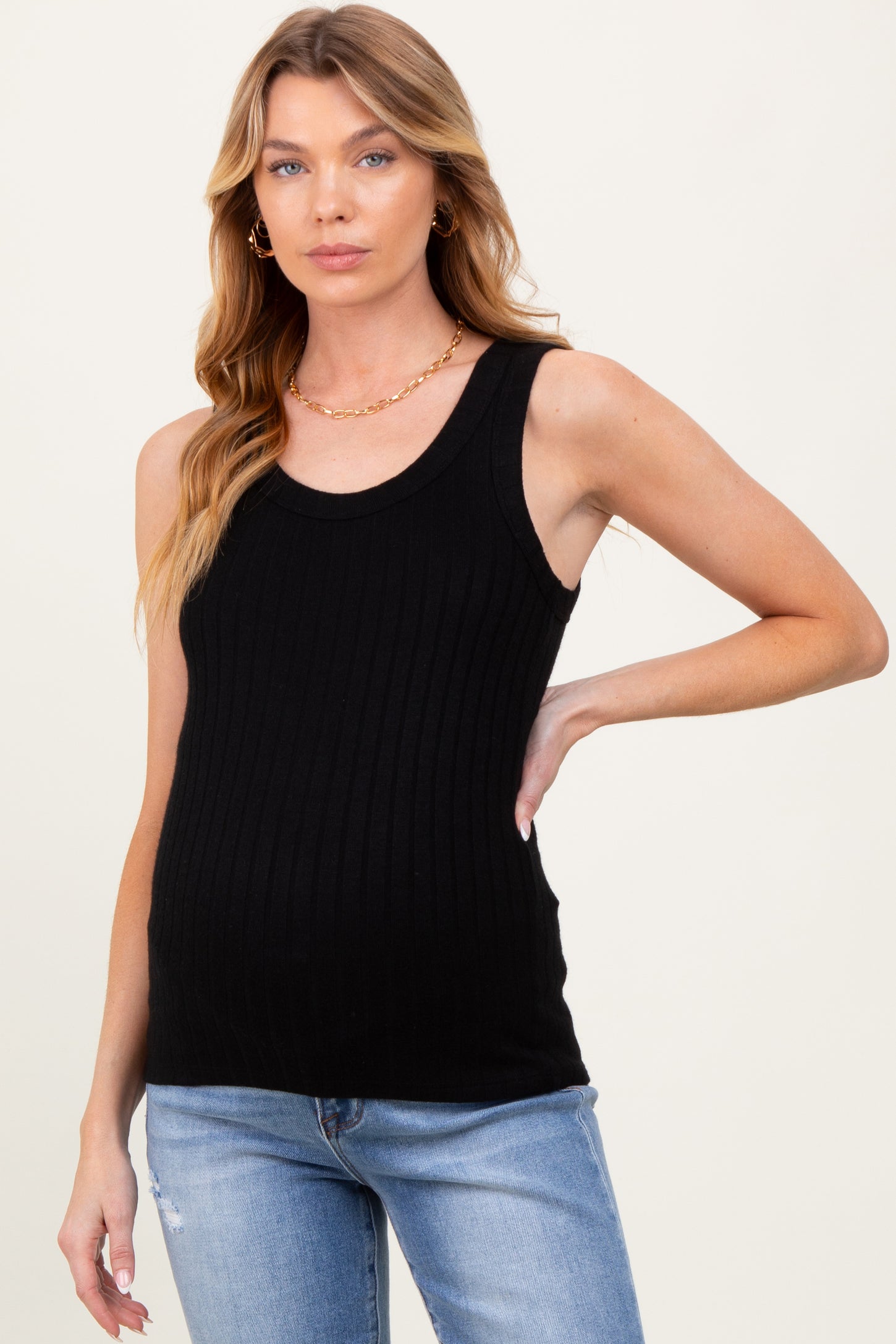 woman wearing a black ribbed maternity tank top and showing her baby bump