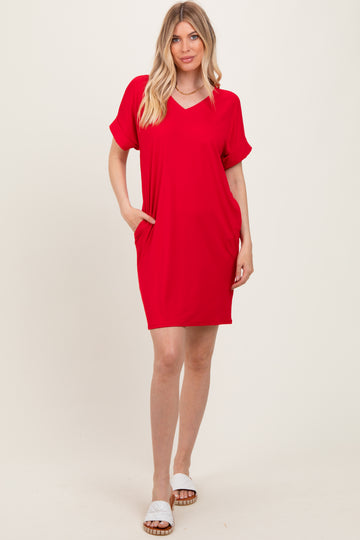 woman wearing a red short sleeve v-neck dress with side pockets and a relaxed fit