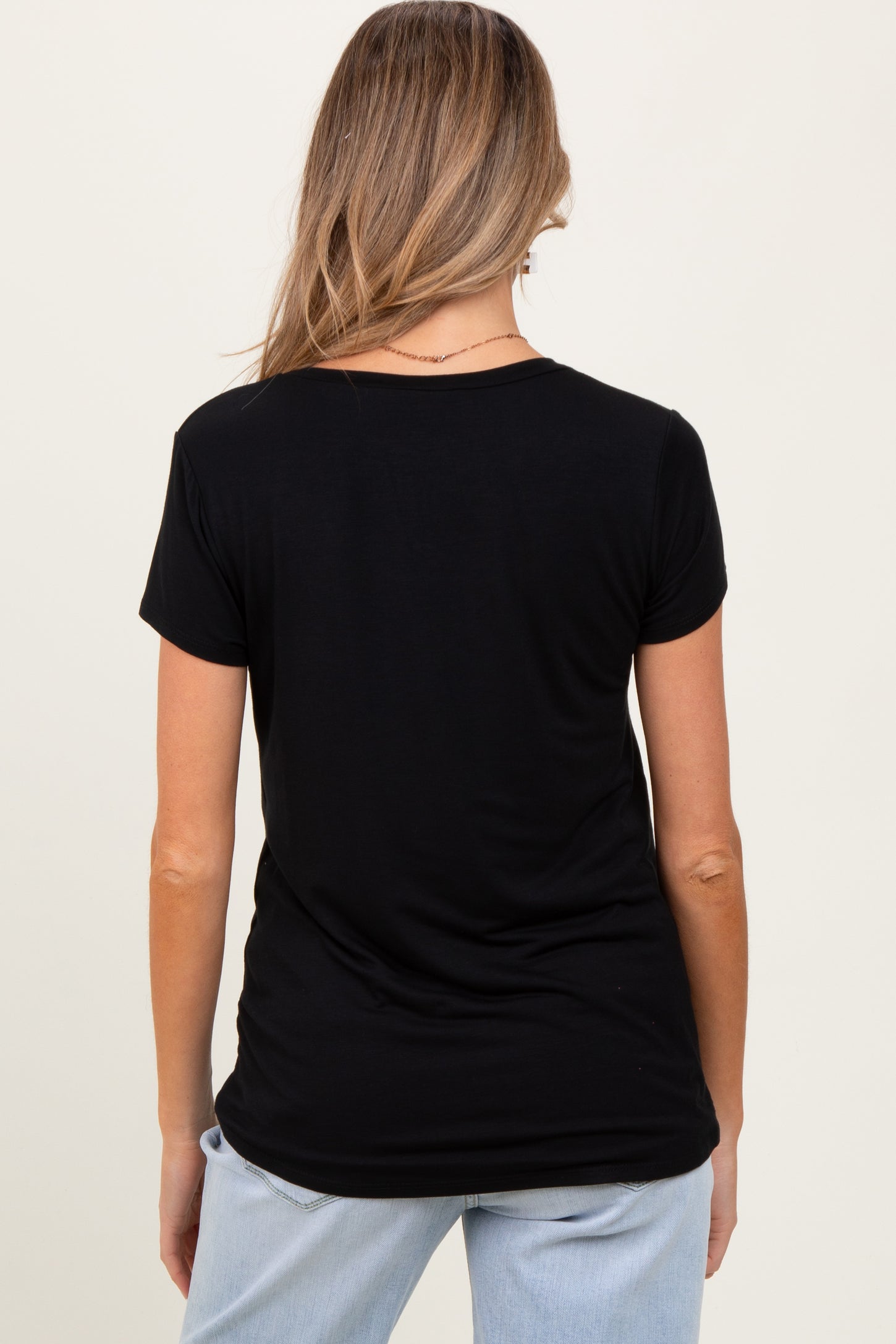 woman wearing a black short sleeve maternity top, viewed from the back