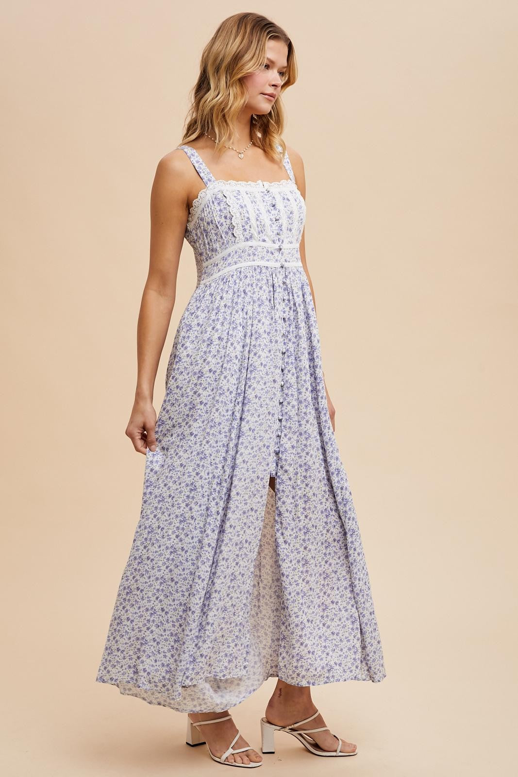 woman wearing a white floral maxi dress with adjustable straps and a button-down front