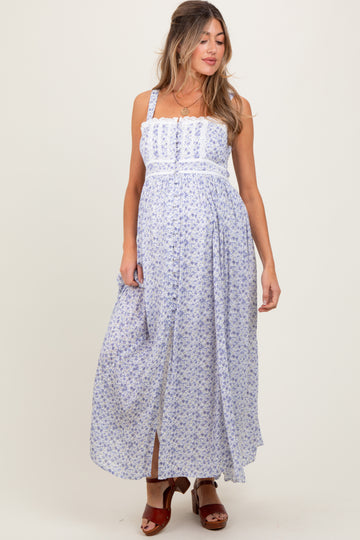 woman wearing a floral print maternity maxi dress with adjustable straps and a flowing skirt, showcasing her baby bump