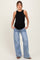 woman wearing a black ribbed maternity tank top and light blue wide-leg jeans, showcasing her baby bump