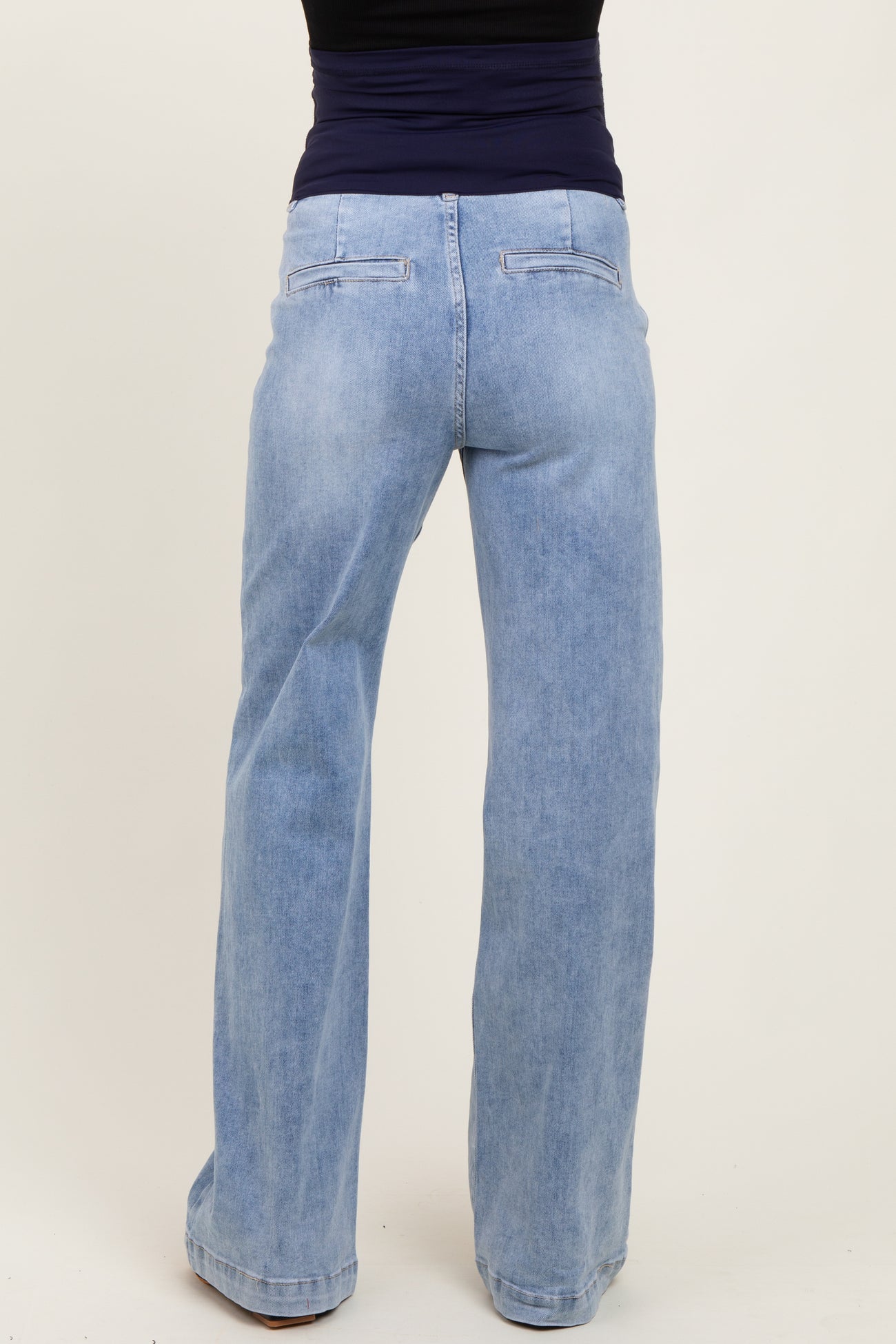 woman wearing light blue maternity flared jeans, seen from the back