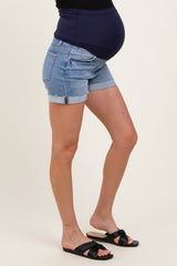 woman wearing maternity denim shorts with a dark blue underbelly panel, showing a visible baby bump