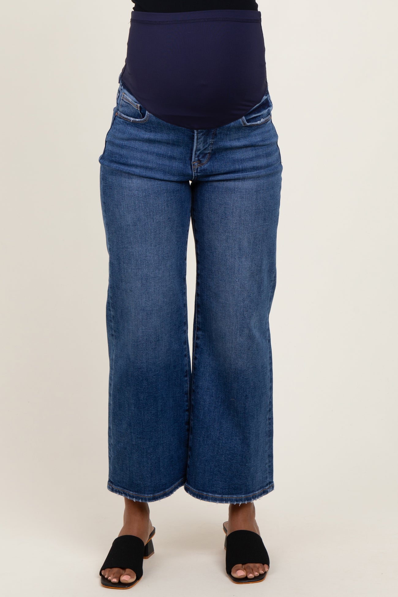 woman wearing a blue maternity wide-leg jeans with a stretchy waistband and showing a baby bump